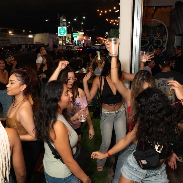 Patrons dancing and socializing at Servehzah Bottle Shop & Tap Room at night.
